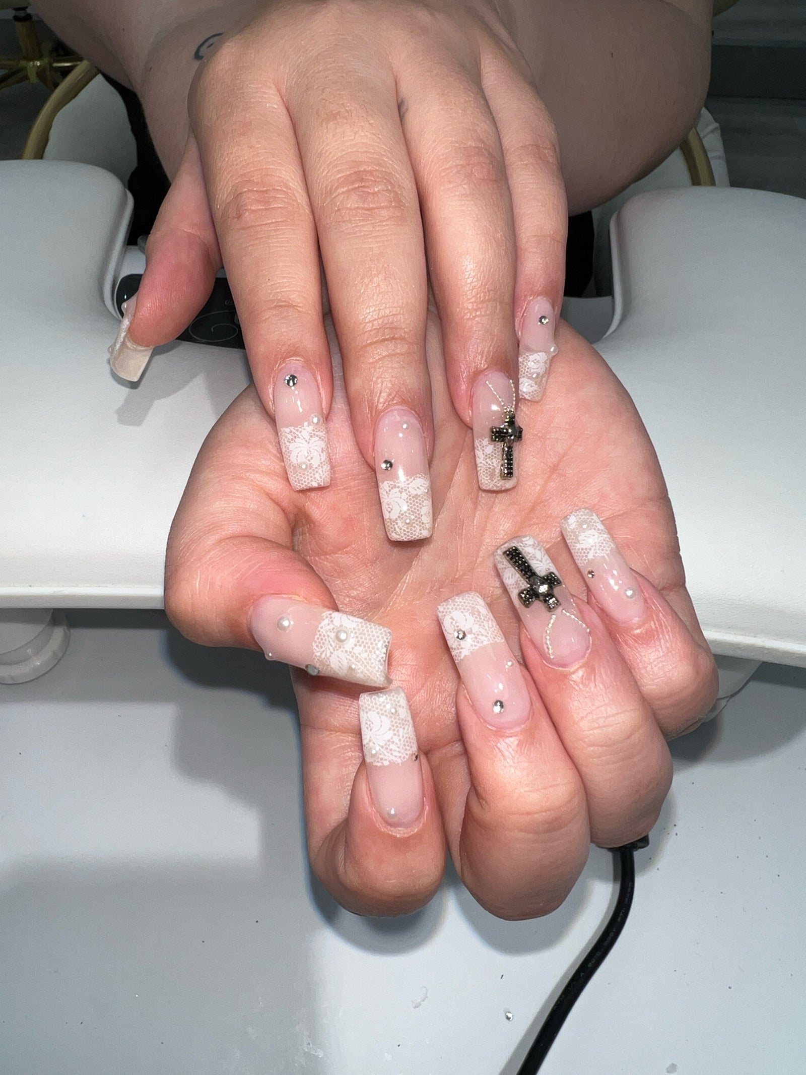 Long square Gel-X extensions in milky white lace with cross charms