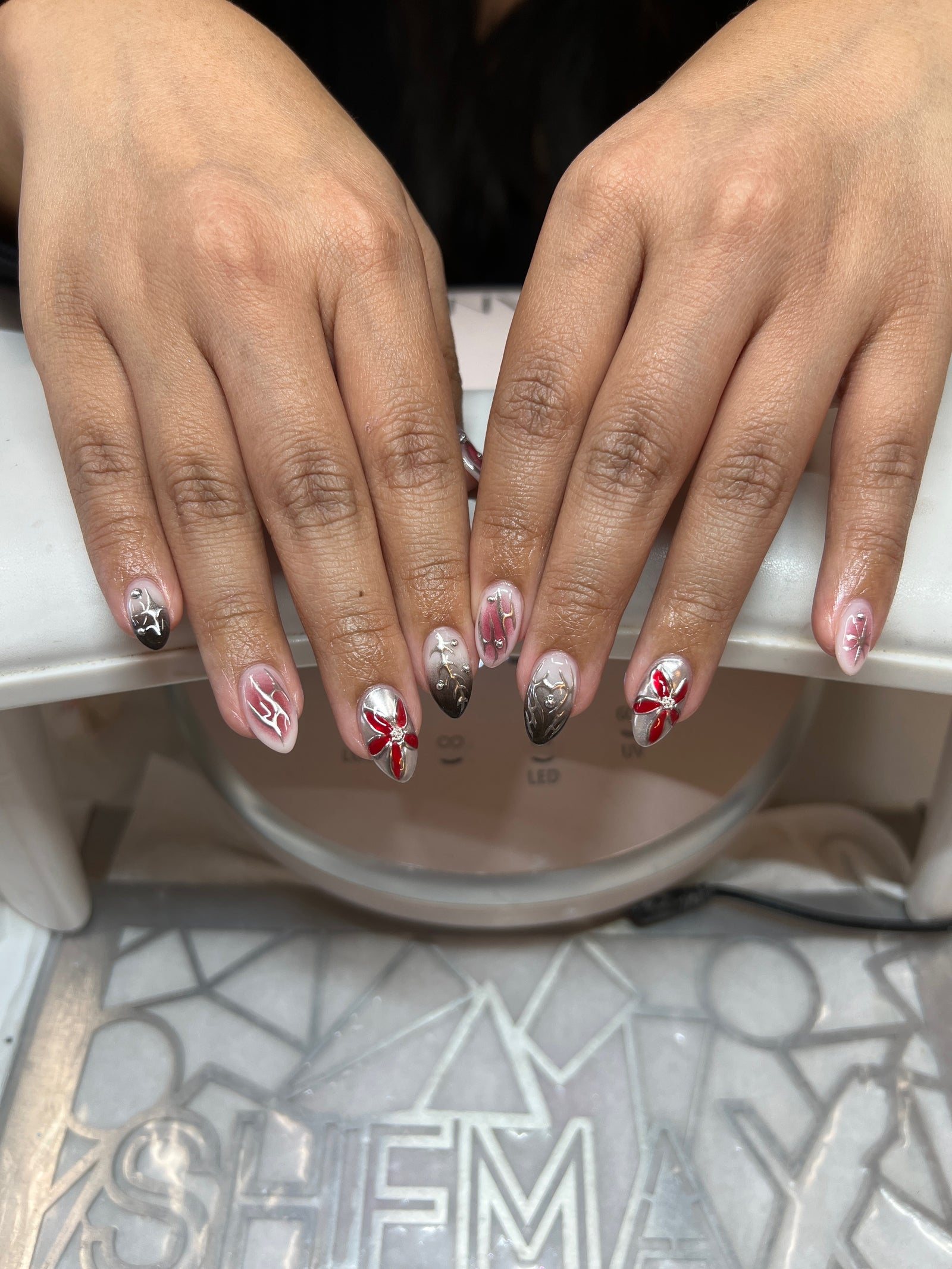 Short nude nails with red flowers and silver chrome details