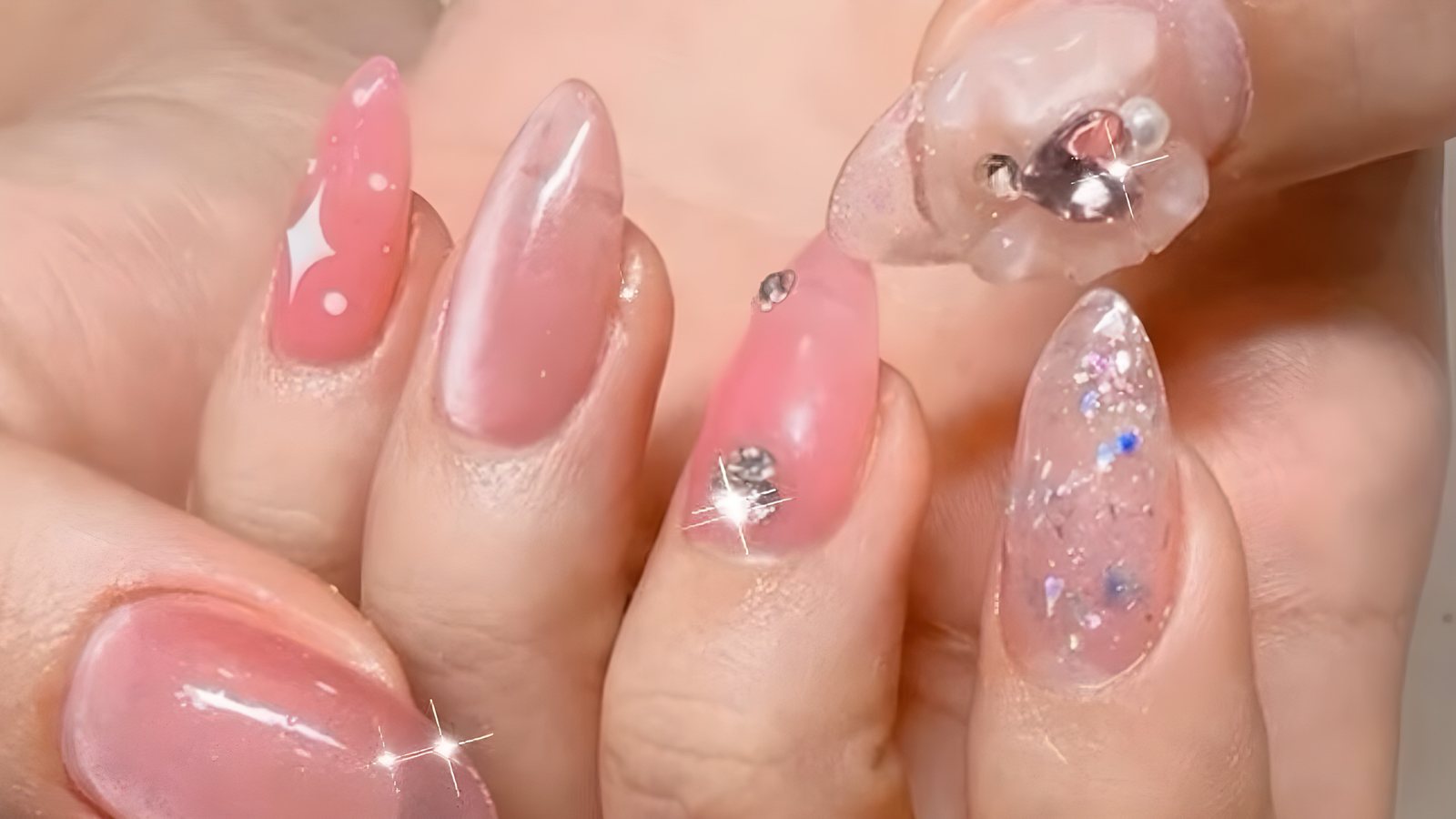 크리스탈 스톤과 3D 리본 파츠를 올린 핑크 젤리 아몬드 네일