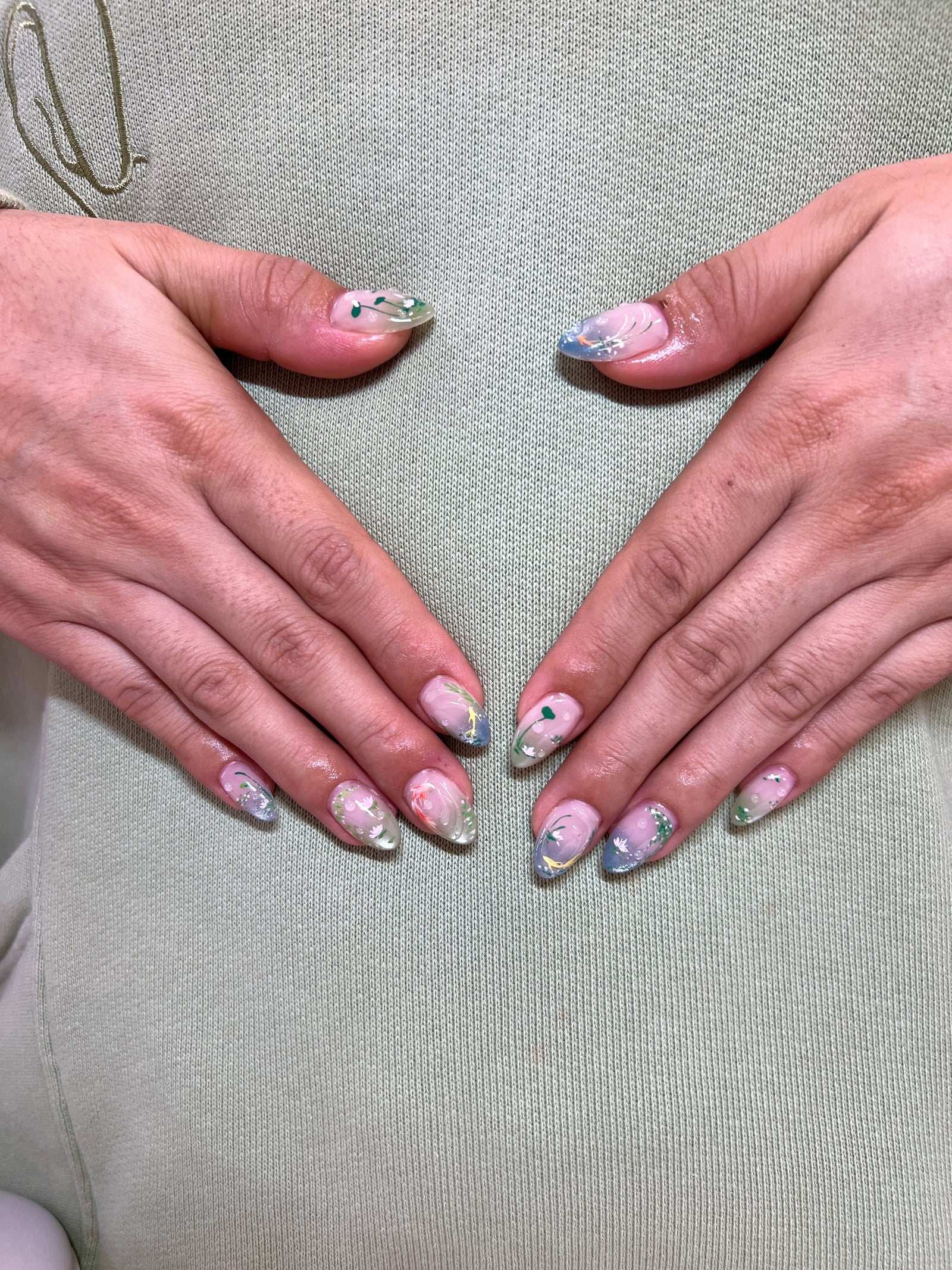 Pastel almond nails with chrome French tips and small stone accents