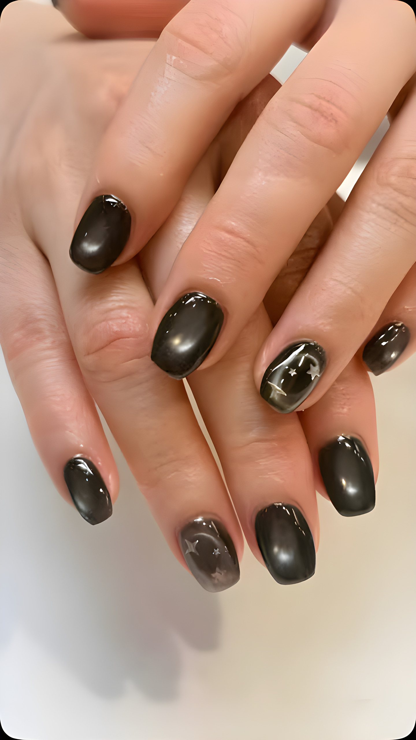 Black cat-eye chrome nails with silver stone accents